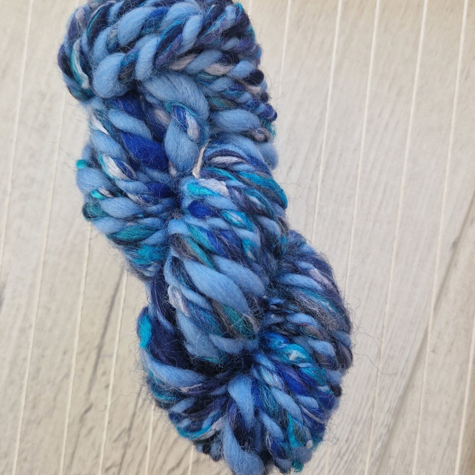 Blue skein of yarn on a wooden loom