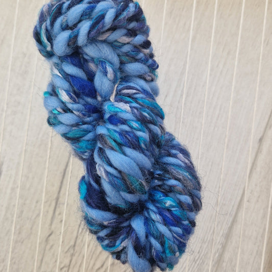 Blue skein of yarn on a wooden loom