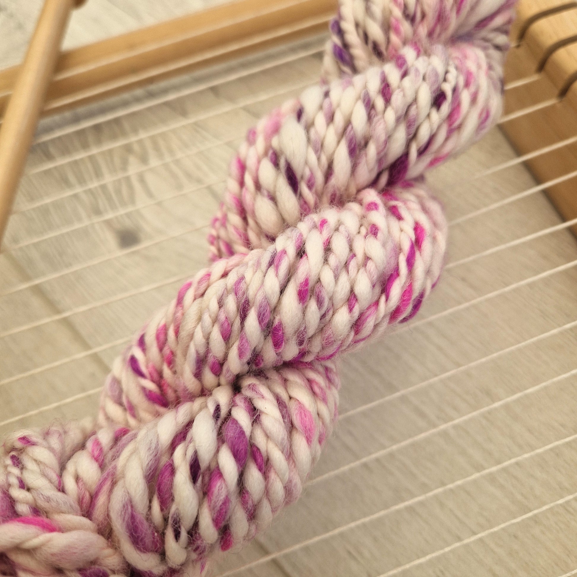striped pink and white yarn on a wooden background