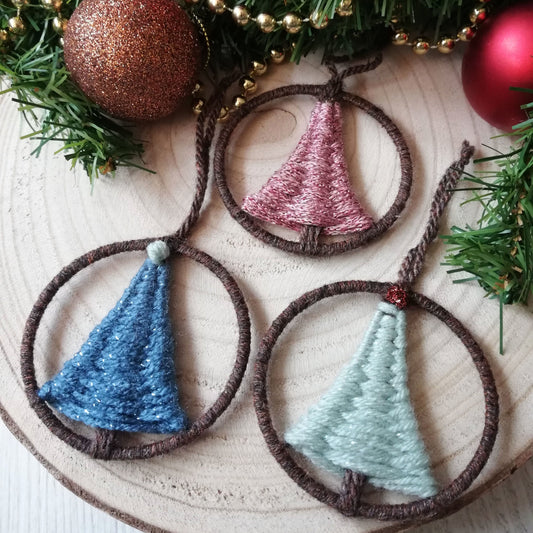 Handwoven tree decorations. Circular hoops with a dtraignular shaped christmas tree woven in the centres and a knotted 'star' on the top.